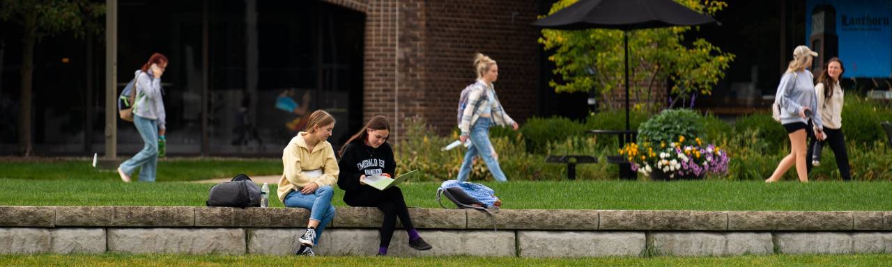 Students sitting near Zumberge pond studying